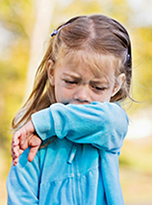 girl coughing into arm